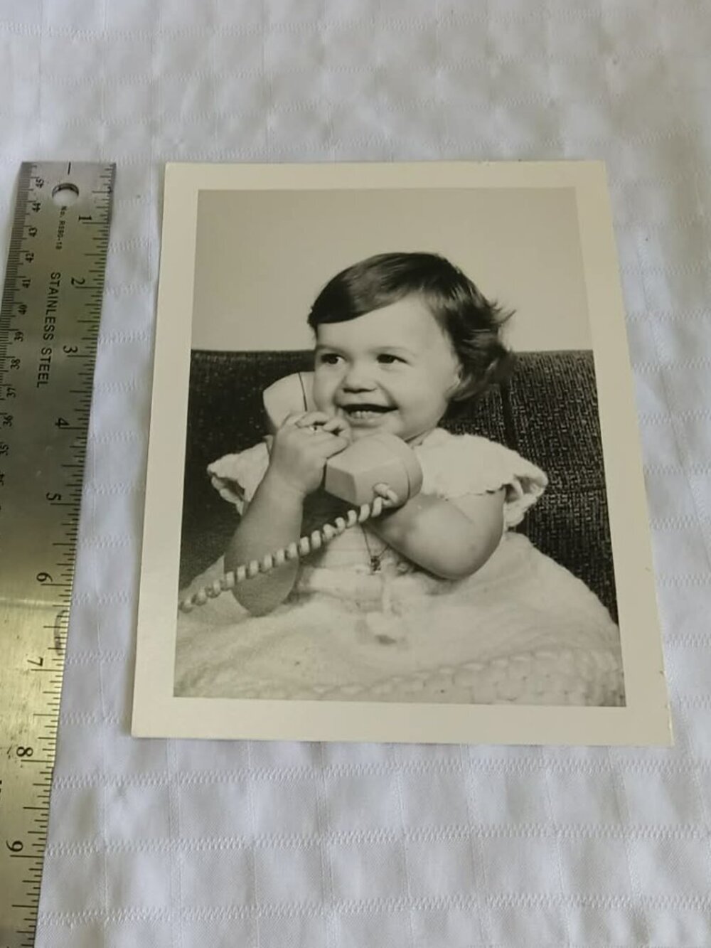 Old black'n'white picture to frame featuring a little girl and a retro telephone